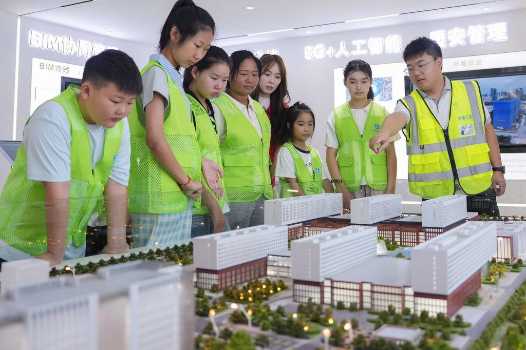 8月13日，“小候鸟”们在建设工程项目部展示厅了解建筑建造原理及施工进展。