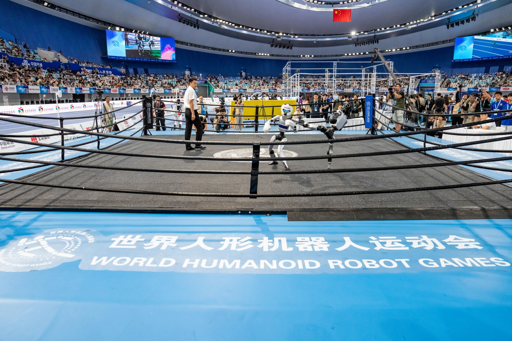 8月23日，北京航空航天大学-北京人形智能凌峰队机器人（右）和冰城铁甲队机器人在自由搏击40KG级1/16决赛中。最终，冰城铁甲队获胜。新华社记者 孙非 摄