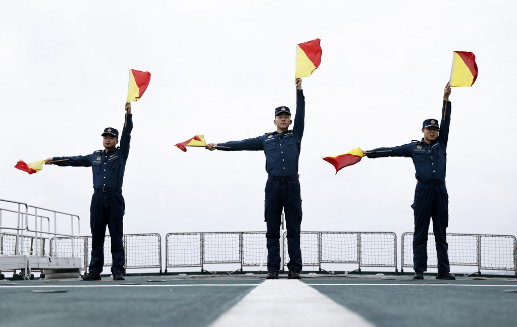 8月17日,海陵舰执法员在甲板进行手旗通信训练。