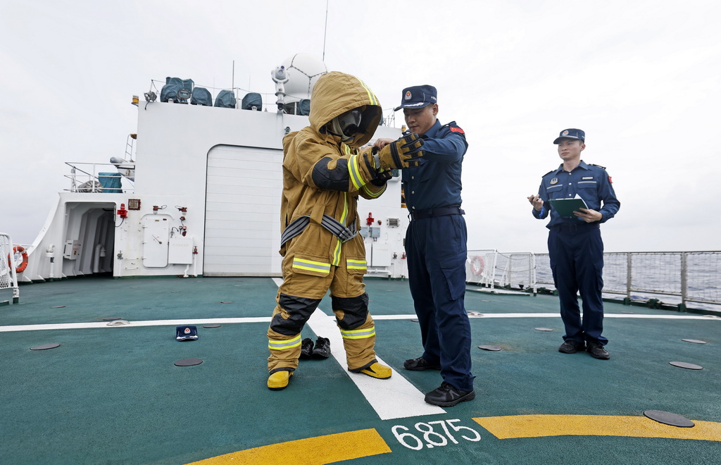 8月17日，海陵舰执法员在甲板进行穿戴防火服训练。