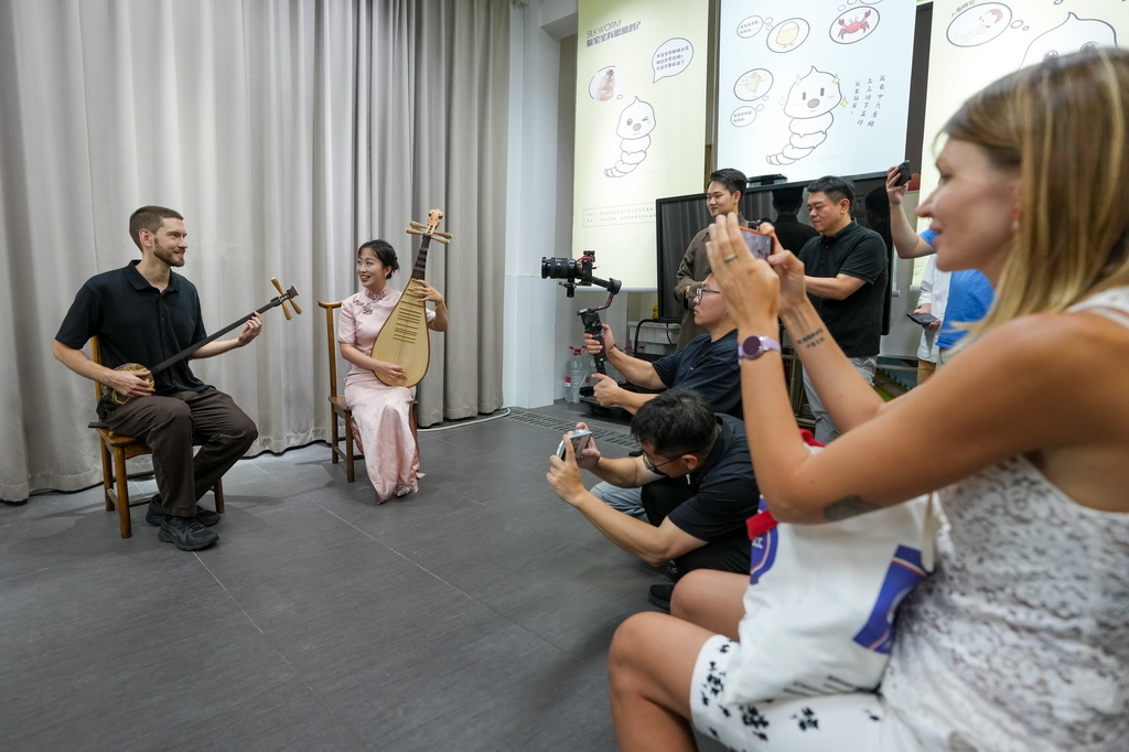 8月22日，中俄记者联合采访团成员在江苏省苏州市与评弹演员互动。