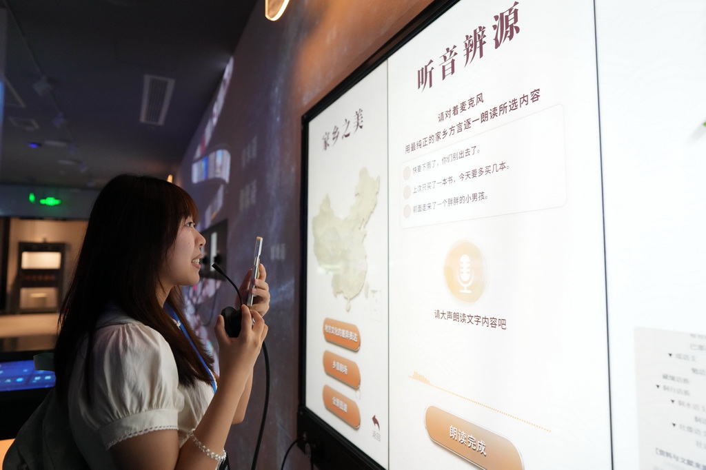 8月24日，观众在中国语言资源保护工程成果展示馆体验“听音辨源”。观众向麦克风说出方言后，机器可识别出观众的家乡。