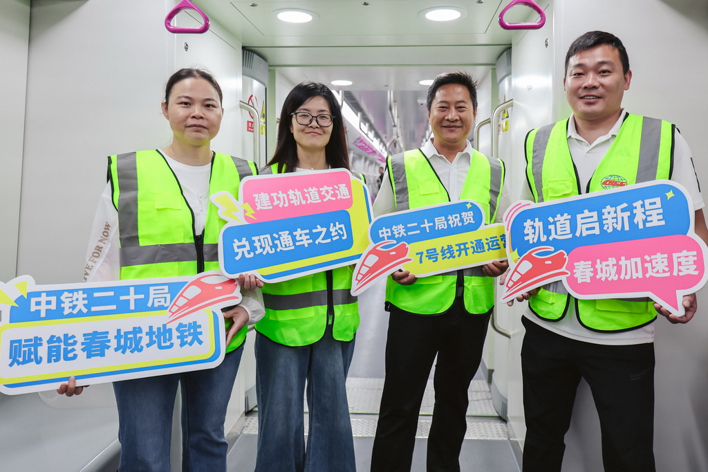 8月26日，长春地铁7号线建设者在地铁列车上拍照留念。