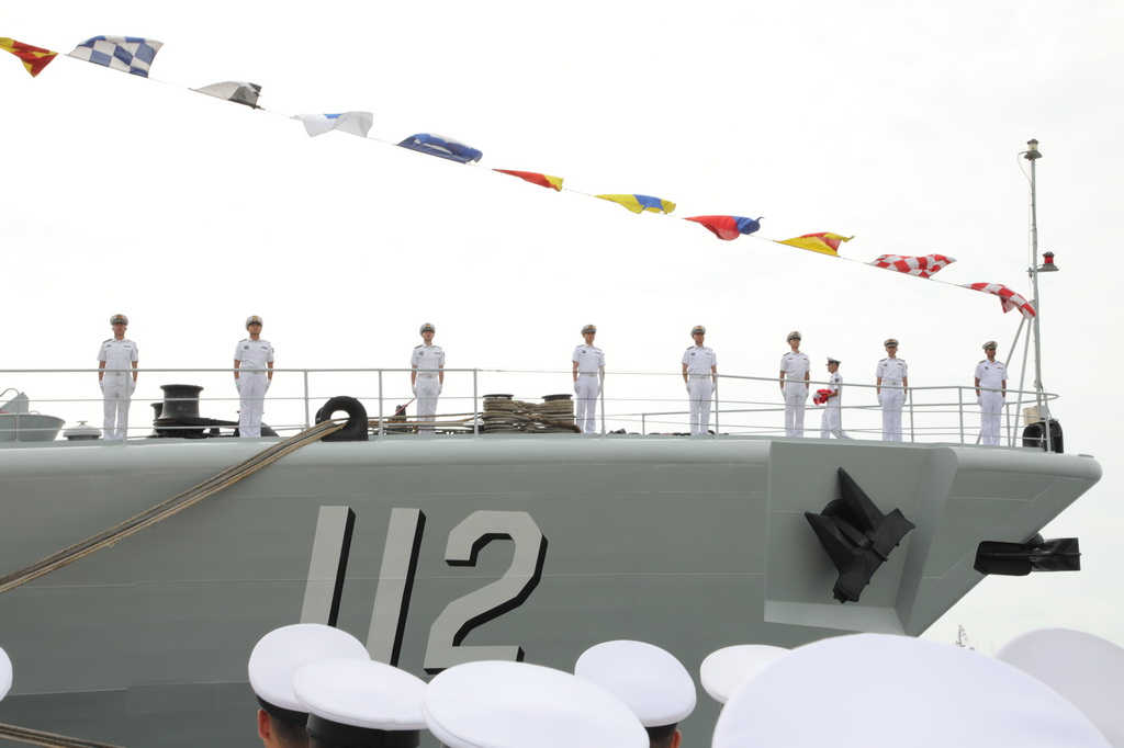 8月28日，被譽為“中華第一艦”的我國第二代國產導彈驅逐艦首艦112艦在青島某軍港退出現役。這是旗手手捧軍旗離艦。新華社記者 李秉宣 攝