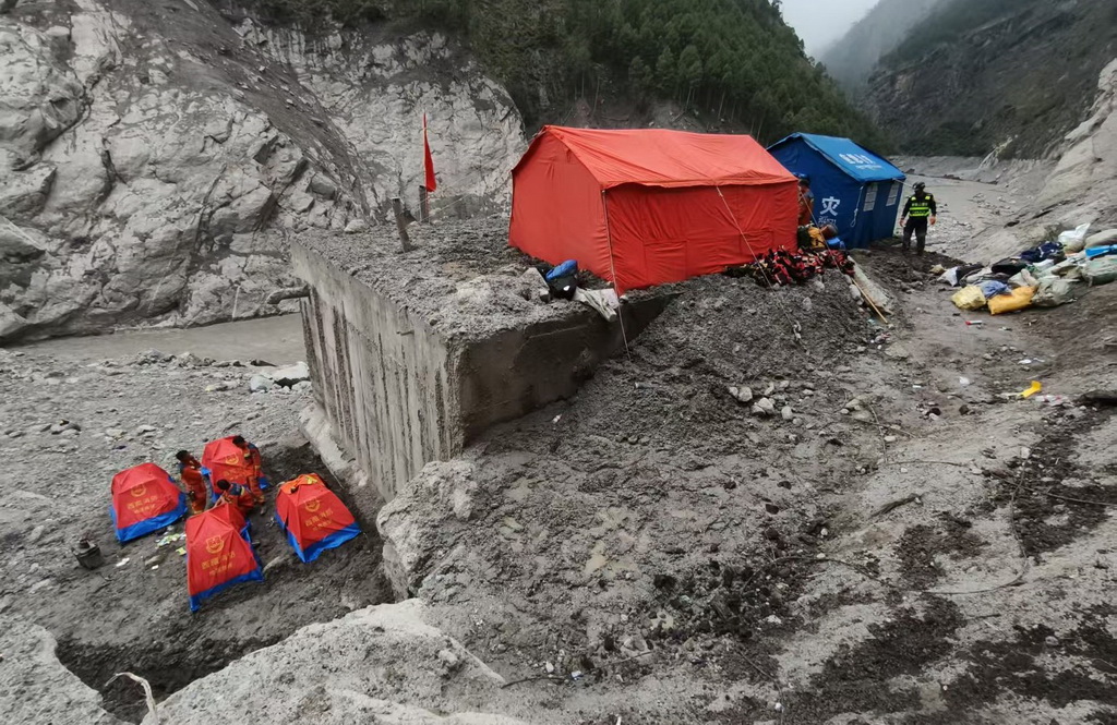 8月31日，救援人员在蓄水池旁和顶盖上搭建帐篷。