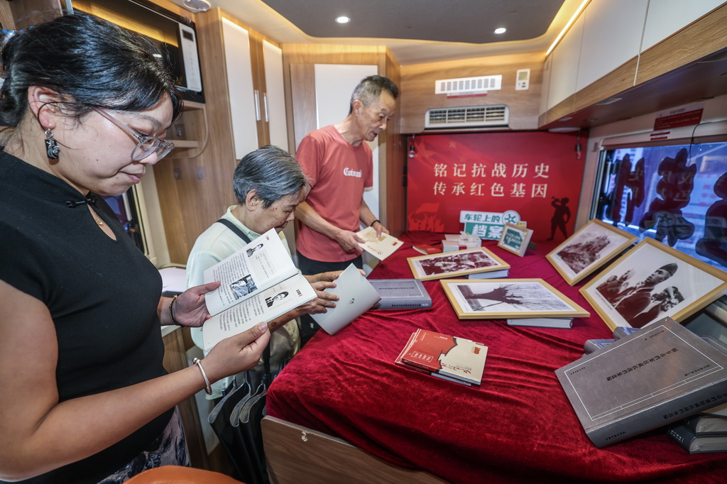 9月2日，桐乡市振东社区的居民在“车轮上的档案馆”流动展览车上参观。