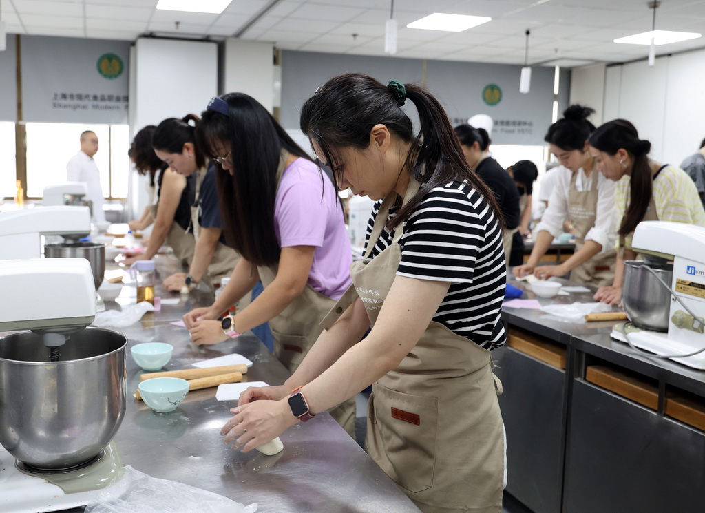 9月7日，在上海市现代食品职业技能培训中心教学点，上海市民日校的学员们在中式面点课上练习揉面。