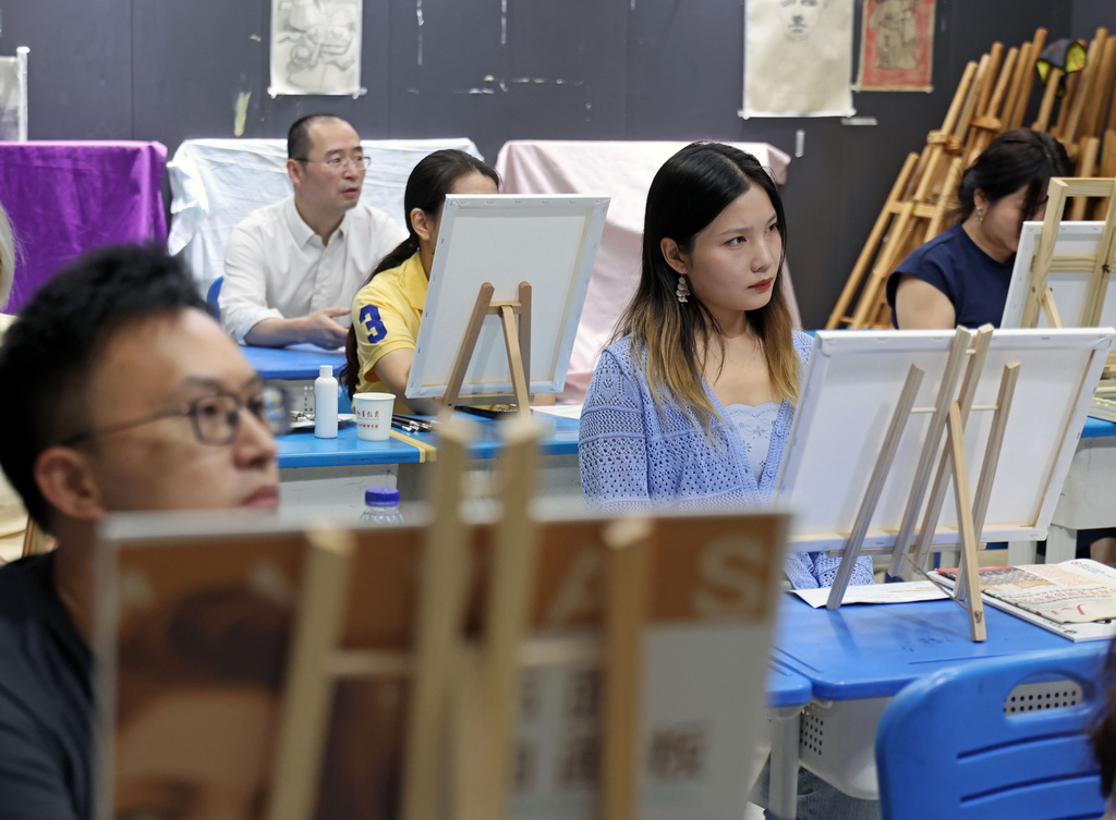 9月7日,在上海市闵行区新华专修学校教学点,上海市民艺术夜校的学员们在风景油画课上听讲。