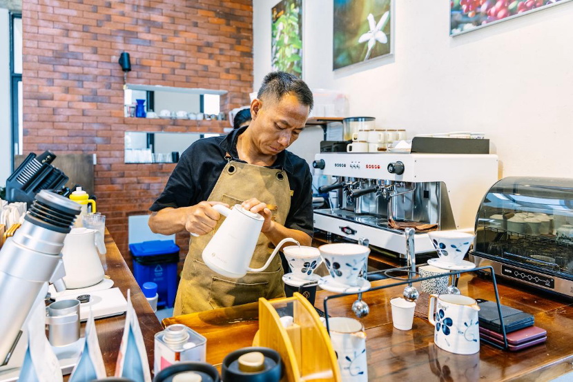 秋珀咖啡庄园里，店员在冲调咖啡。王剑摄
