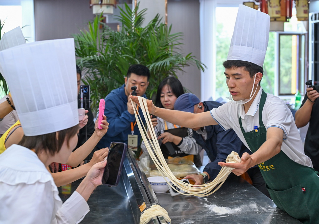 9月12日，两岸媒体人在甘肃省兰州市体验制作兰州牛肉面时采访拍摄。