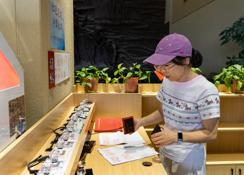 9月19日,一名游客在红军长征湘江战役纪念馆盖章留念。