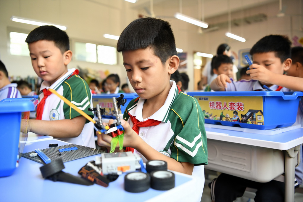 9月23日，在山东省莒县沭东花园小学，智启机器人社团的学生在练习组装机器人。