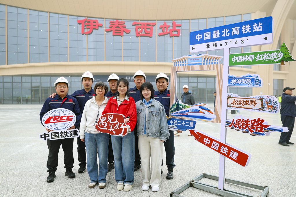 9月28日，哈伊高鐵建設人員與游客在伊春西站站前廣場合影。新華社記者 張濤 攝