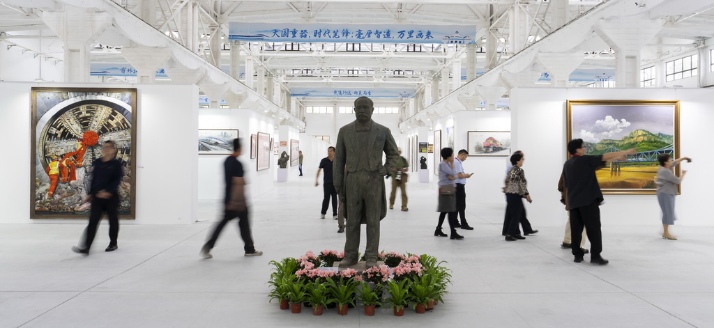 9月29日，在北京中车二七智能制造园，观众在詹天佑塑像旁参观。