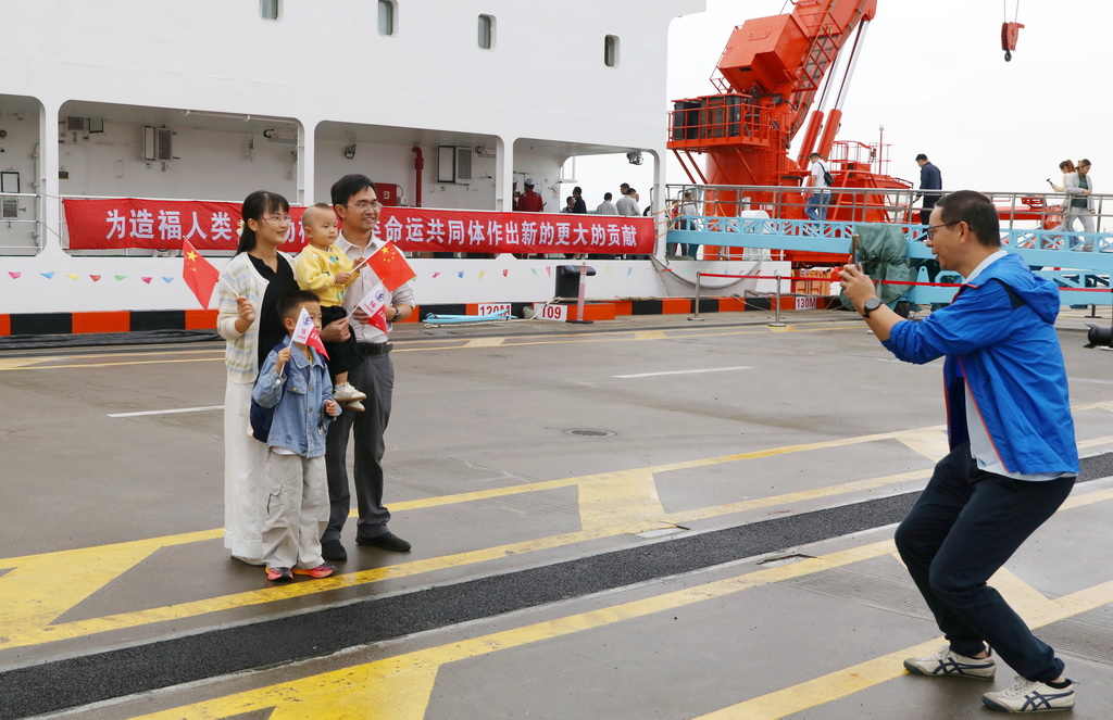 9月30日，科考队员和前来迎接的家人在中国极地考察国内基地码头合影留念。新华社记者 温竞华 摄