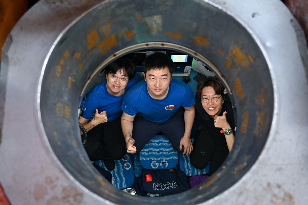 10月10日，參加此次下潛作業的潛航員傅文韜（中）、張奕（左）以及自然資源部第二海洋研究所助理研究員周凡煜在潛水器內合影。