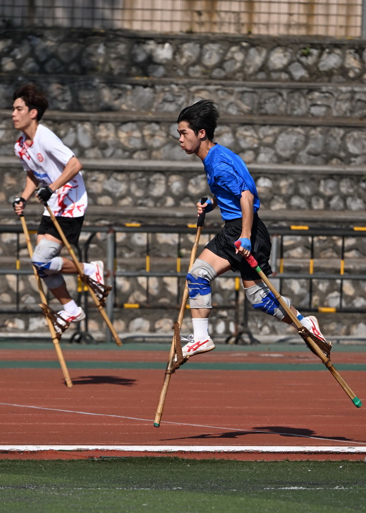 10月12日，梧州市代表團高腳競速隊隊員張榮鑫（右）在男子高腳競速比賽中。