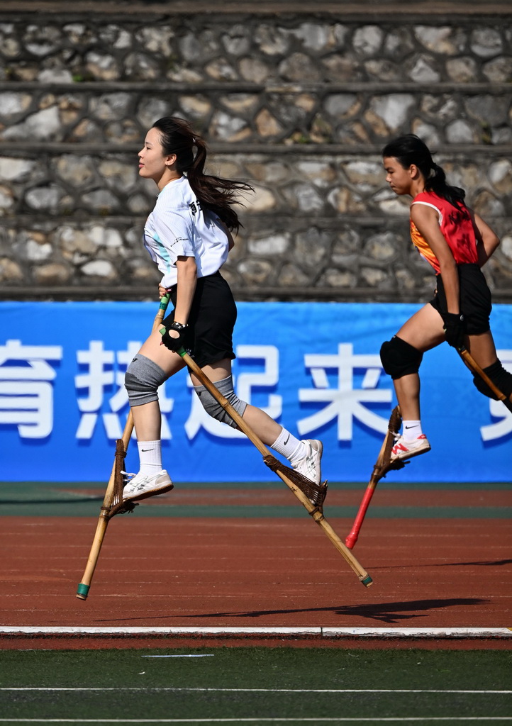 10月12日，南寧師范大學代表團高腳競速隊隊員梁靜怡（左）在女子高腳競速比賽中。