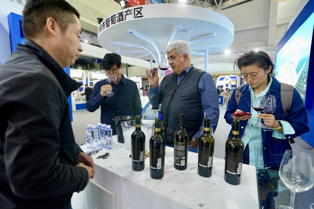 10月13日，观众在博览会上品鉴、了解葡萄酒。