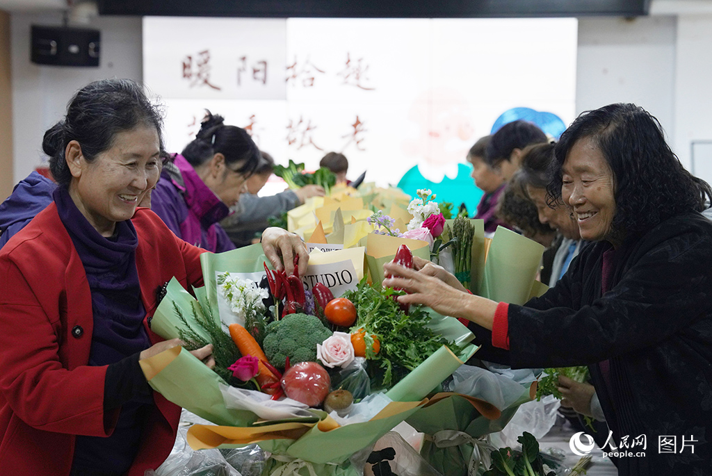 10月16日，吉林省长春新区双德街道阳光社区开展重阳节创意蔬菜花束 DIY 手工活动，老年居民们动手搭配鲜花与新鲜蔬菜，制作别致的蔬菜花束。人民网记者 李成伟摄