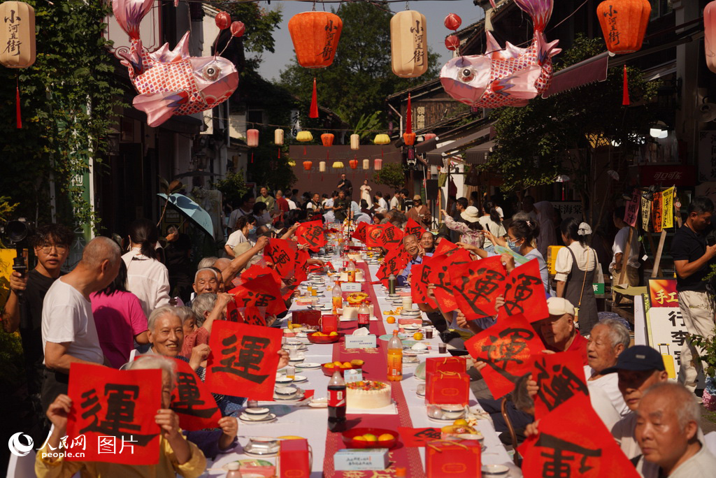 10月18日，杭州市拱墅区小河街道第二十五届重阳长桌宴在小河直街开席，百名长者欢聚一堂，共庆重阳。人民网 章勇涛摄