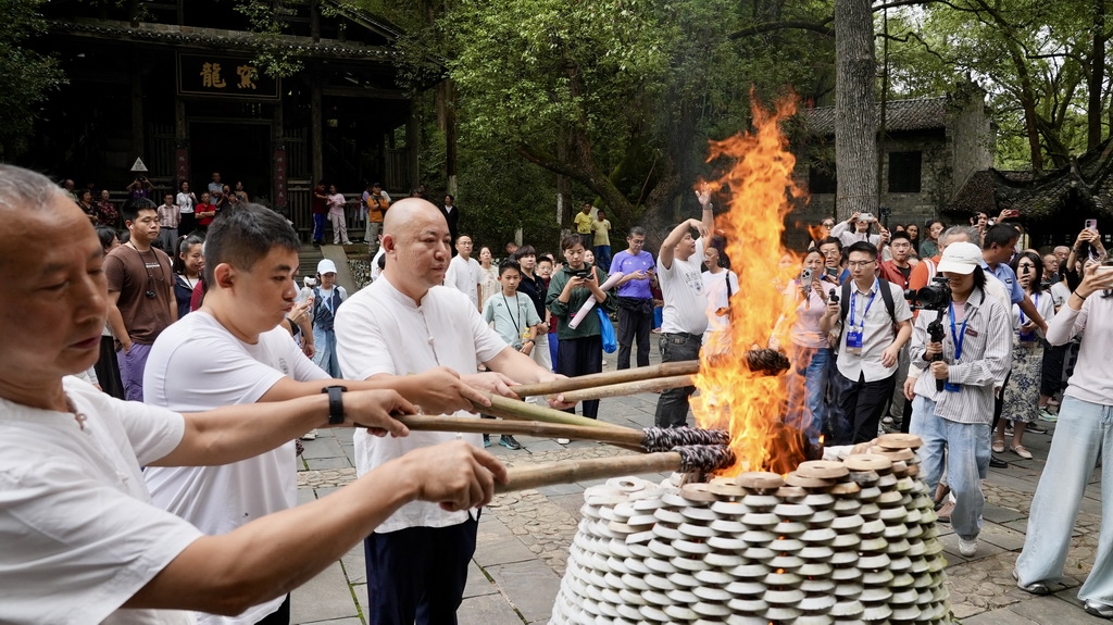 10月19日，在馒头窑的点火仪式上，古窑民俗博览区的制瓷师傅点燃火把。