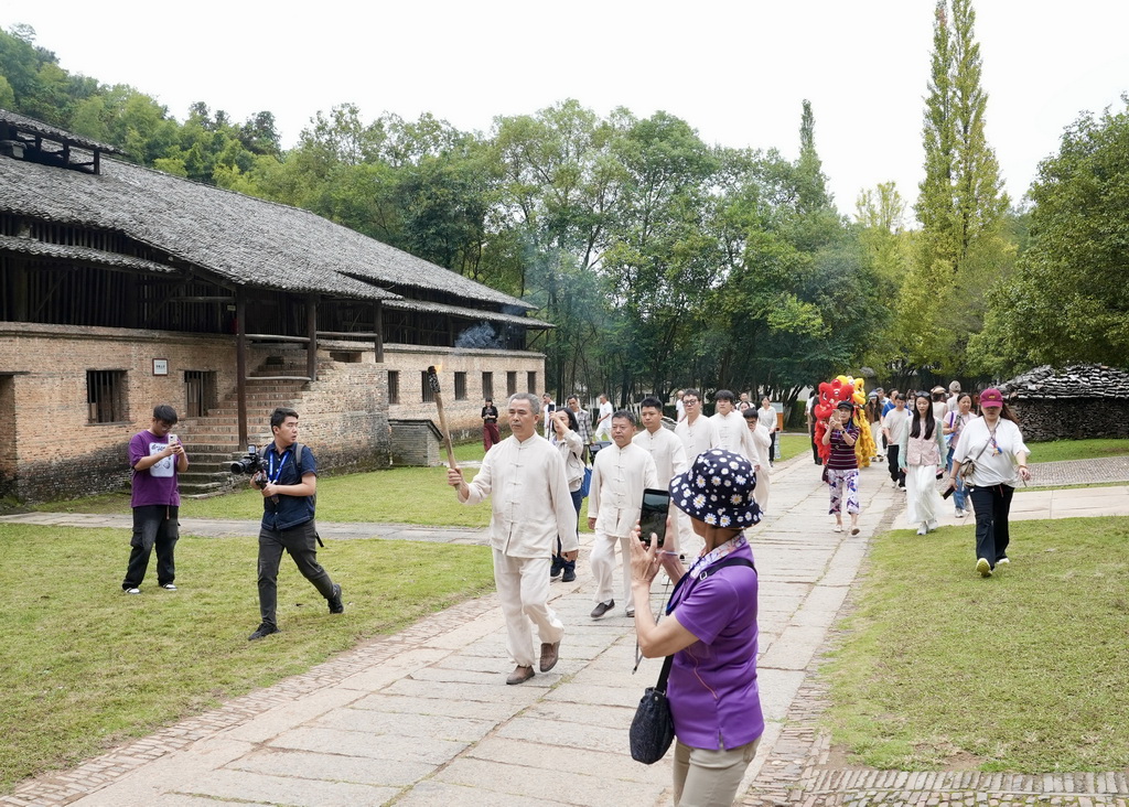 10月19日，点火仪式前，古窑民俗博览区的工作人员在景区内传递复烧馒头窑的火种。