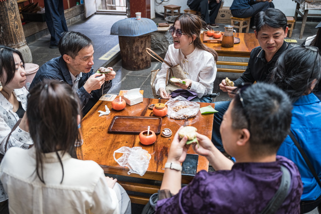 10月19日，游客在腾冲市清水镇三家村中寨司莫拉佤族村品尝大米粑粑。