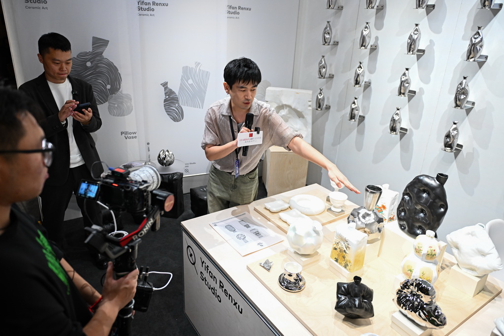 10月20日，第13届嘉德艺术周的展商工作人员在介绍参展作品。