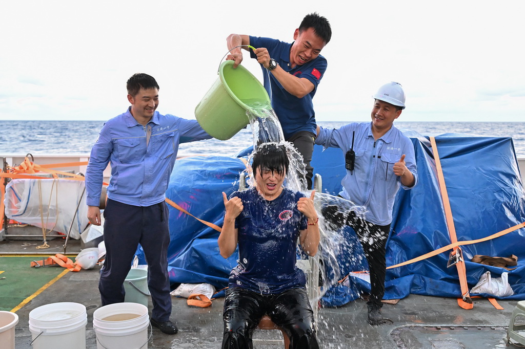 9月30日,“蛟龙”号进行第464次下潜作业,深度达7035.3米。这是潜航员张奕(前)突破个人下潜深度后接受泼水庆祝。新华社记者 叶昊鸣 摄