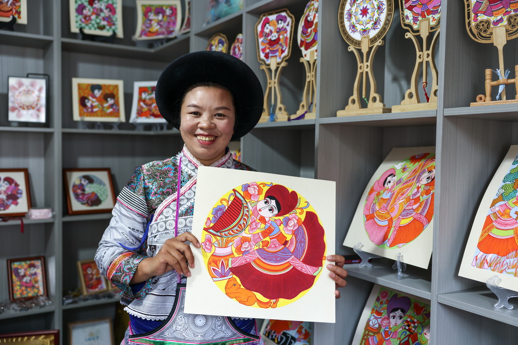 贵州省六盘水市水城区陡箐镇陡箐村的画师罗班妹在展示农民画（10月5日摄）。