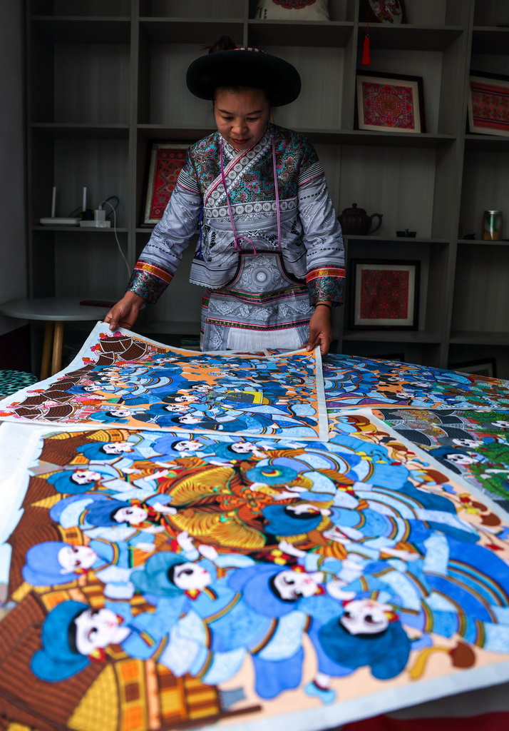 贵州省六盘水市水城区陡箐镇陡箐村的画师罗班妹在展示农民画（10月5日摄）。