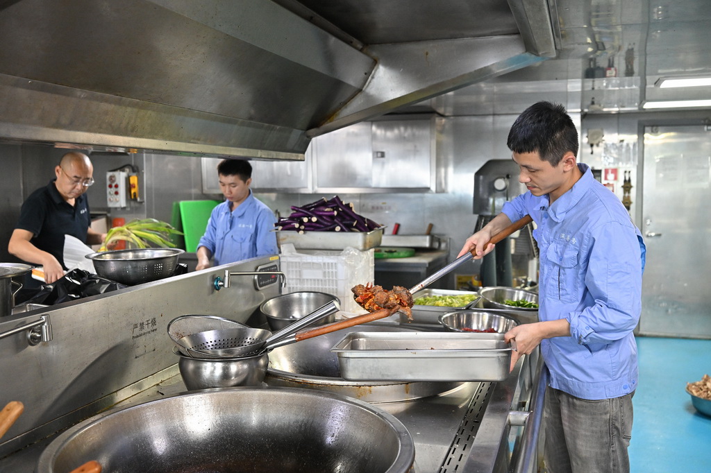 10月23日，厨师蔡鄂（右）、谭吉林（中）、牟积生在为船上人员准备午餐。新华社记者 叶昊鸣 摄