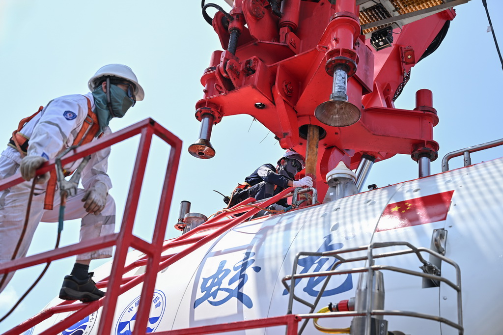 10月10日，“蛟龙”号水面支持人员为“蛟龙”号挂主吊缆，准备布放。新华社记者 李鑫 摄