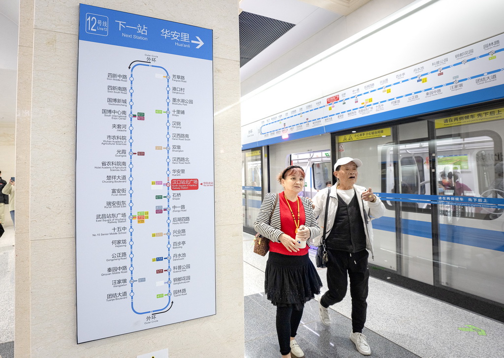 10月29日，在汉口站北广场站，人们乘坐武汉地铁12号线列车。