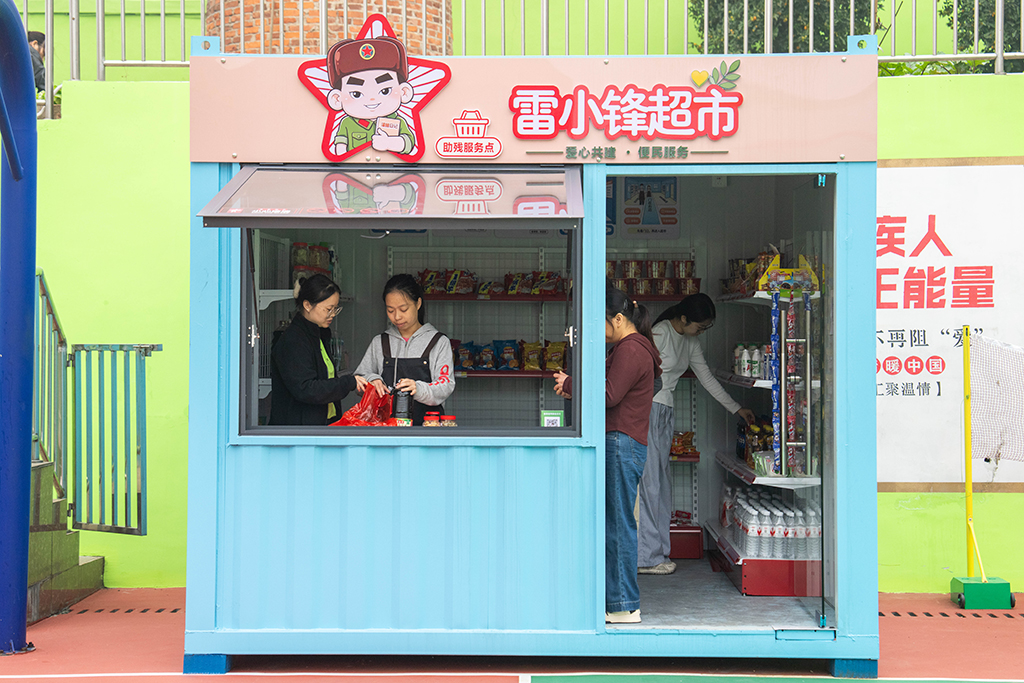 10月29日，在望城区星羽残疾人托养中心模拟超市，学员（左二）在进行收银训练。