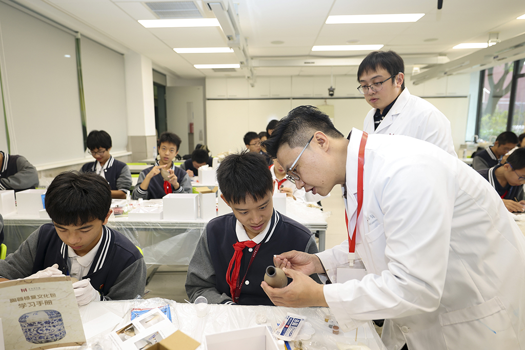 10月29日，上海博物館文保專家在“破損陶瓶的修復體驗”手工工作坊上指導學生制作。