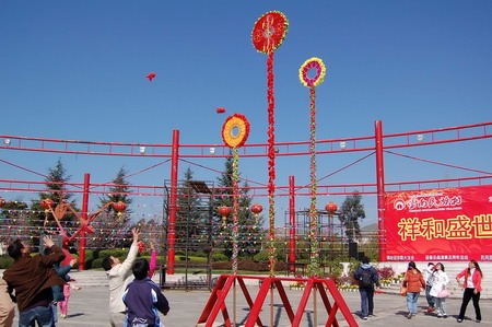 2月7日,游客在昆明云南民族村做抛绣球游戏.