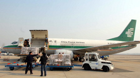 工作人员正往中国货运邮政航空公司的邮政飞机