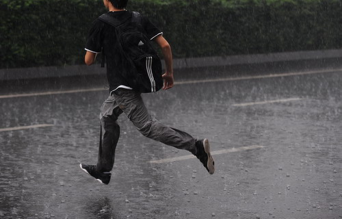 一名成都市民在雨中奔跑