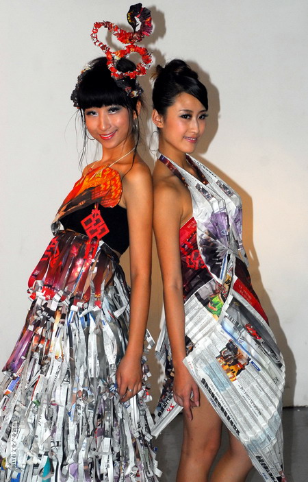 两名海南大学的学生模特展示用废旧报纸制作的创意晚礼服.