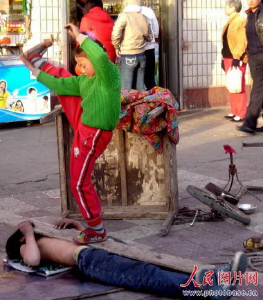 河南洛阳:幼童街头卖艺险象横生 (2)