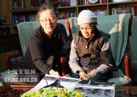 图为侯波在儿媳的陪伴下翻看徐肖冰的作品集。