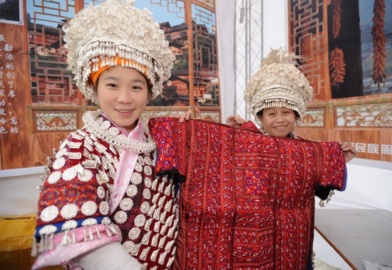 两位来自贵州凯里的苗族少女在展示纯手工绣制