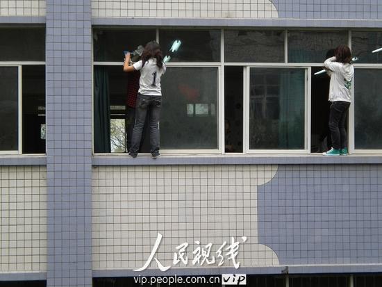 西南某大学为迎双评 学生教室窗外擦玻璃