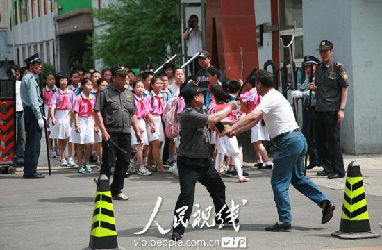 一歹徒想伤害学生,现场保安和巡防人员用手中的钢叉,警棍与歹徒搏斗.