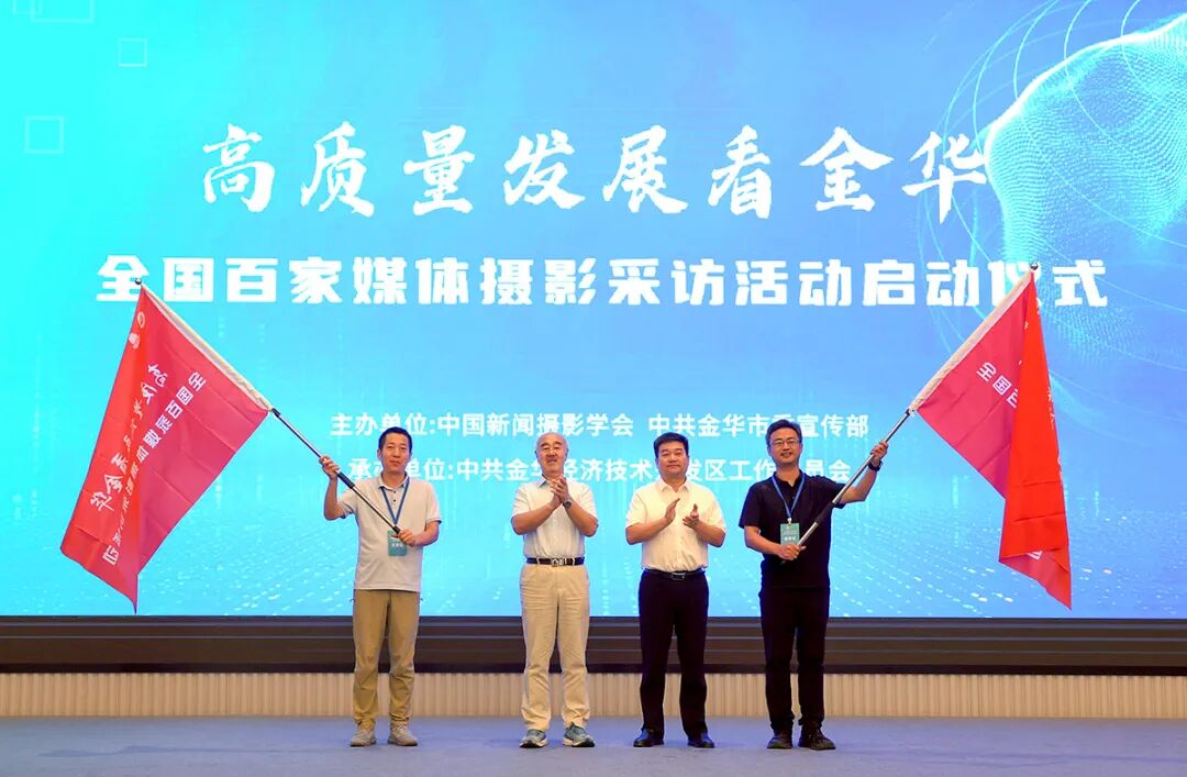 图为中国新闻摄影学会会长兰红光（左二）、金华市委宣传部副部长、市网络舆情导控中心主任童咏雷（右二）为2个摄影采访小组授旗。中国日报记者 耿菲菲 摄