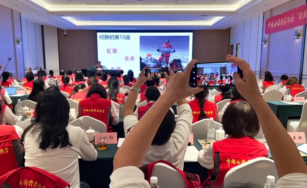 何静分享登顶珠穆朗玛峰时展示中国女摄影家协会横幅。靳雪莉 摄